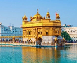 The Golden Temple (Harmandir Sahib) in Amritsar, gold-plated shrine on the sacred pool with a marble walkway and visitors nearby.